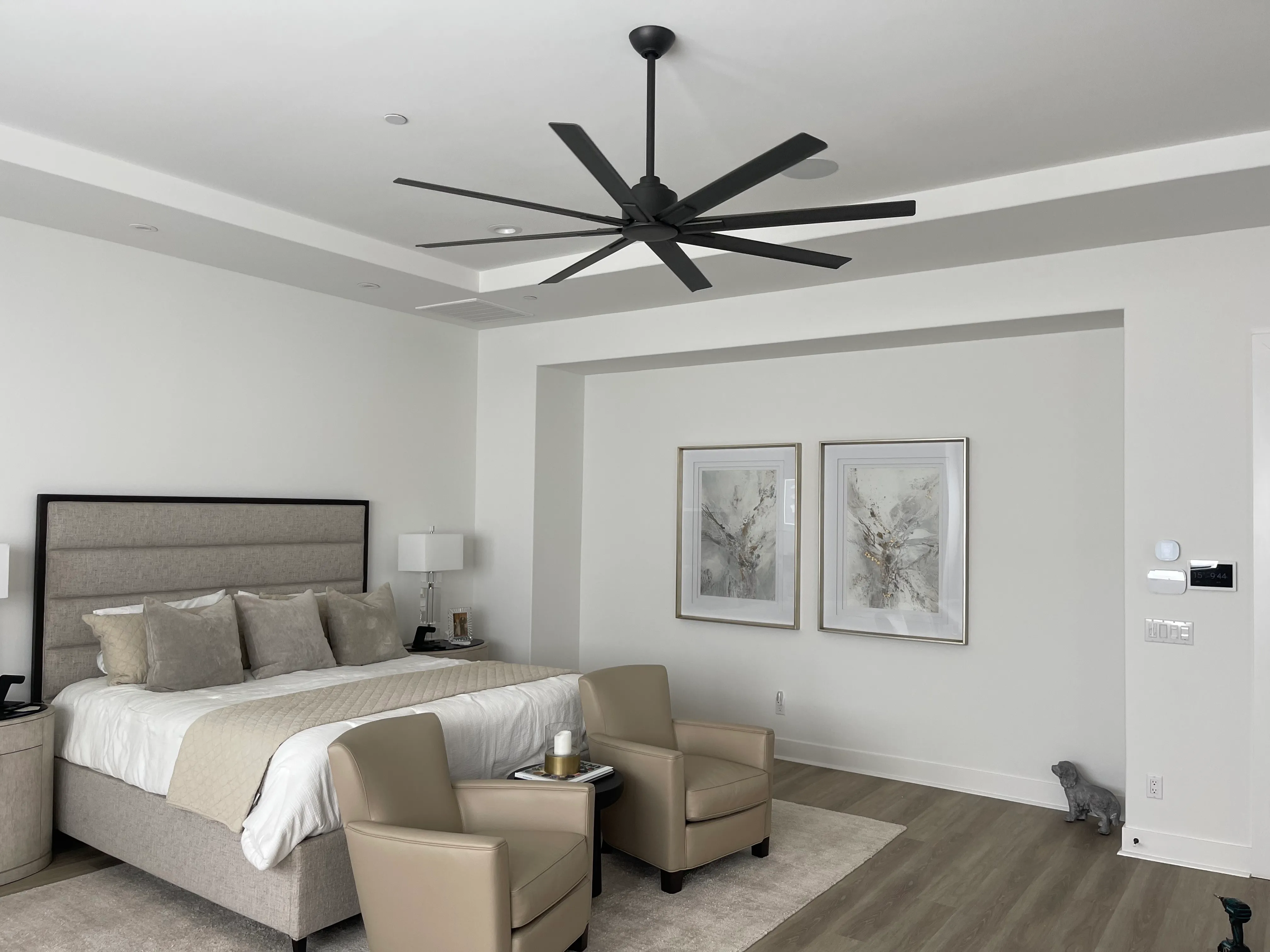 Ventilador de techo negro de gran tamaño en una recámara principal de lujo, con panel de control Legrand adorne — instalación de Fan Diego.